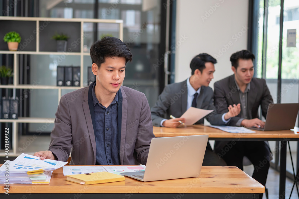 Asian business team consists of marketing staff. accountant and financial officer Help each other analyze company profits using tablets. calculator Laptop computers, graph paper, and corporate pens. Asian business team consists of marketing staff. accountant and financial officer Help each other analyze company profits using tablets. calculator Laptop computers, graph paper, and corporate pens.