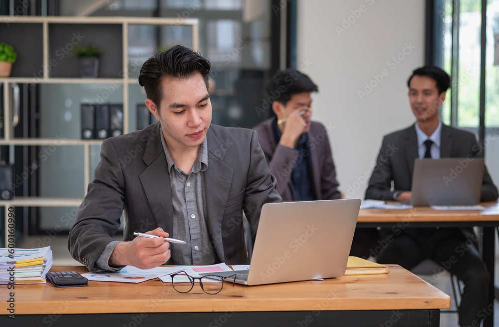 Asian business team consists of marketing staff. accountant and financial officer Help each other analyze company profits using tablets. calculator Laptop computers, graph paper, and corporate pens. Asian business team consists of marketing staff. accountant and financial officer Help each other analyze company profits using tablets. calculator Laptop computers, graph paper, and corporate pens.
