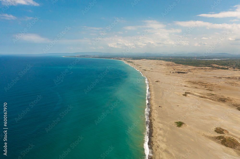 Top view of sandy beach and blue ocean. Paoay Sand Dunes, Ilocos Norte, Philippines.