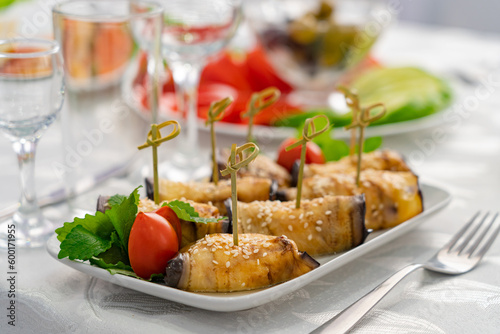 stuffed eggplants and vegetables in a festive table setting with herbs, oranges, lemon and olives