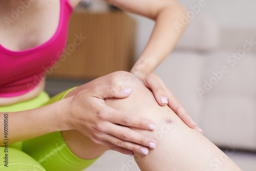 girl in bright sportswear at home knee pain