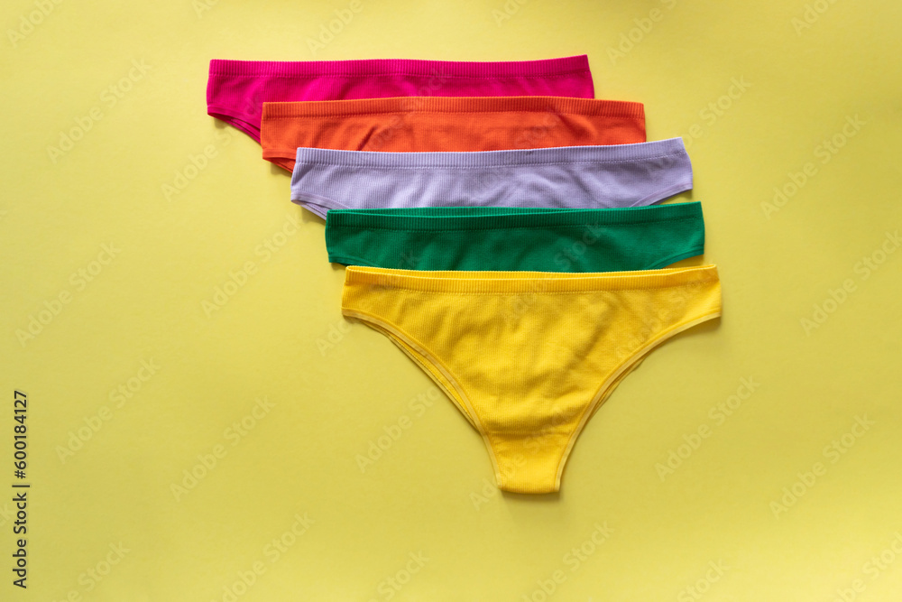 Set of colorful underpants on yellow background, close up