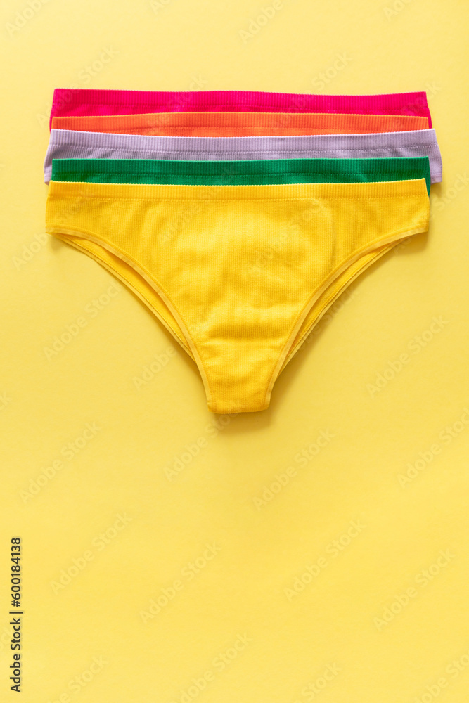 Set of colorful underpants on yellow background, close up Set of colorful underpants on yellow background, close up