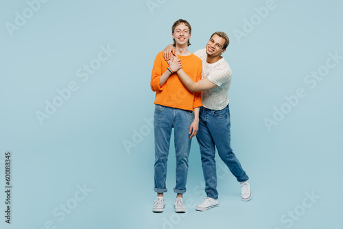 Full body happy young couple two gay men wear casual clothes together hug cuddle looking camera isolated on pastel plain blue color background studio portrait. Pride day june month love LGBTQ concept.