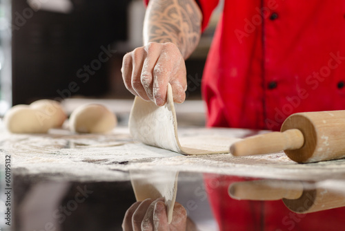 pizzaiolo prepares pizza in the kitchen, the chef prepares the dough