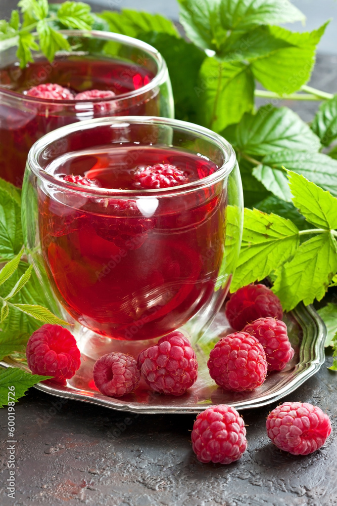 Glass of juice made of raspberries on silver tray Glass of juice made of raspberries on silver tray