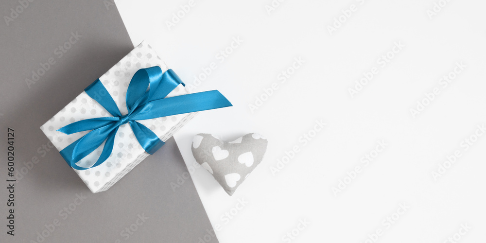 Father's Day celebration concept.Top view flat lay of gift box with satin bluebow and handmade heart isolated on gray and white background with space for text or promotion and greeting message 