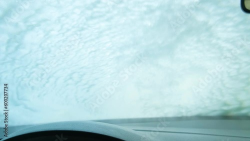 The foam is washed off the windowshield at the car wash. View from the salon photo