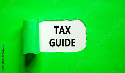 Tax guide symbol. Concept words Tax guide on beautiful white paper. Beautiful green table green background. Business and Tax guide concept. Copy space.