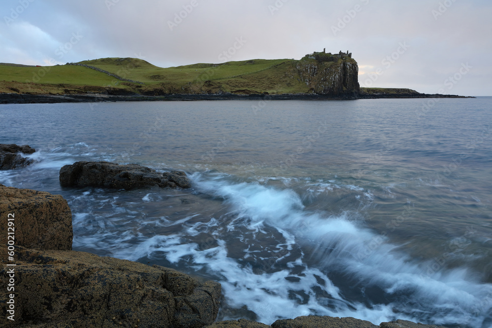 Obraz premium Incoming tide at Sunset with Duntulm Castle in the background, Isle of Skye, Scotland, UK.