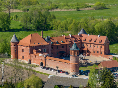 Tykocin castle on sunny day surrounded with green meadows and trees - drone aerial photography Poland