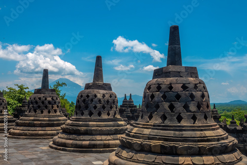 Ancient ruins of Borobudur, (Candi Borobudur) a 9th-century Mahayana Buddhist temple in Magelang Regency, Central Java, Indonesia.The Merapi volcano in the background