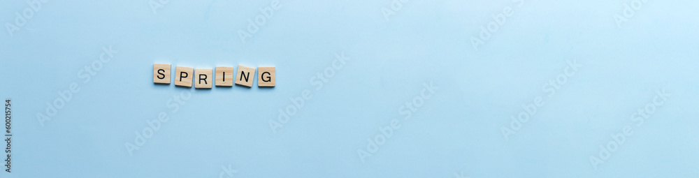 Banner The word spring laid out in wooden letters. Flat lay spring on blue background Banner The word spring laid out in wooden letters. Flat lay spring on blue background