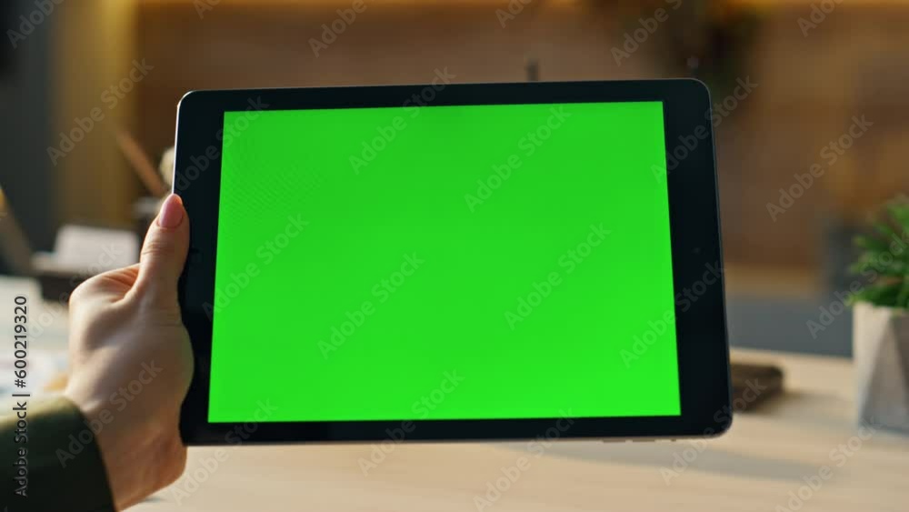 Freelancer hands swiping green screen tablet searching information at workplace.