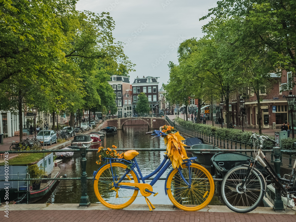 Bright yellow and blue bike on a bridge in Amsterdam (The Netherlands)