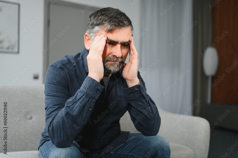 Senior man with headache at home Senior man with headache at home