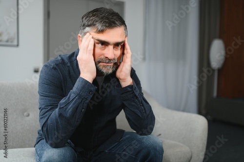 Senior man with headache at home