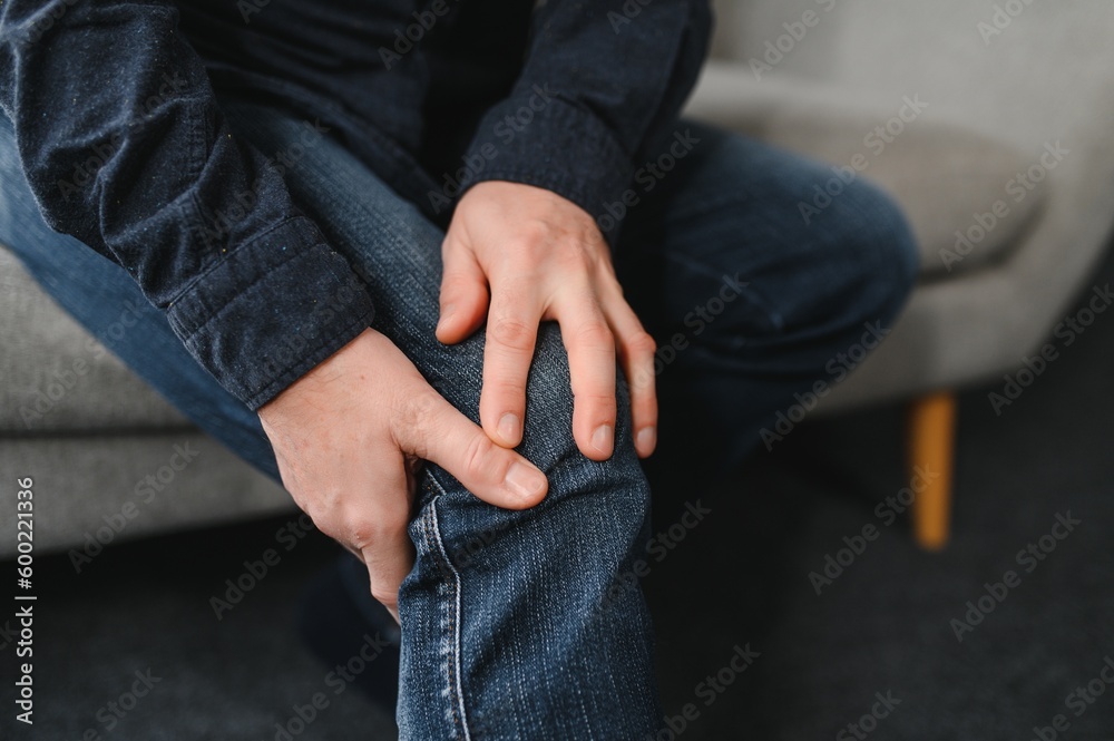 Fototapeta premium people, health care and problem concept - unhappy senior man suffering from knee ache at home