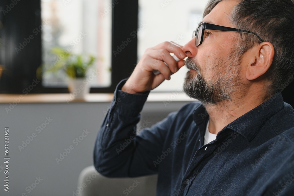 Portrait of man with a nasal spray. Sick man using nose drops while laying at the bed. Concept of treatment for allergies or the common cold, winter style. Portrait of man with a nasal spray. Sick man using nose drops while laying at the bed. Concept of treatment for allergies or the common cold, winter style.