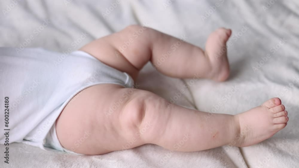 close up baby body parti cute hand fingers legs sole sitting on bed blanket. mother kissing infant toddler feet massage with hands. child moving uncontrollably.motherhood concept advertising 4k close up baby body parti cute hand fingers legs sole sitting on bed blanket. mother kissing infant toddler feet massage with hands. child moving uncontrollably.motherhood concept advertising 4k