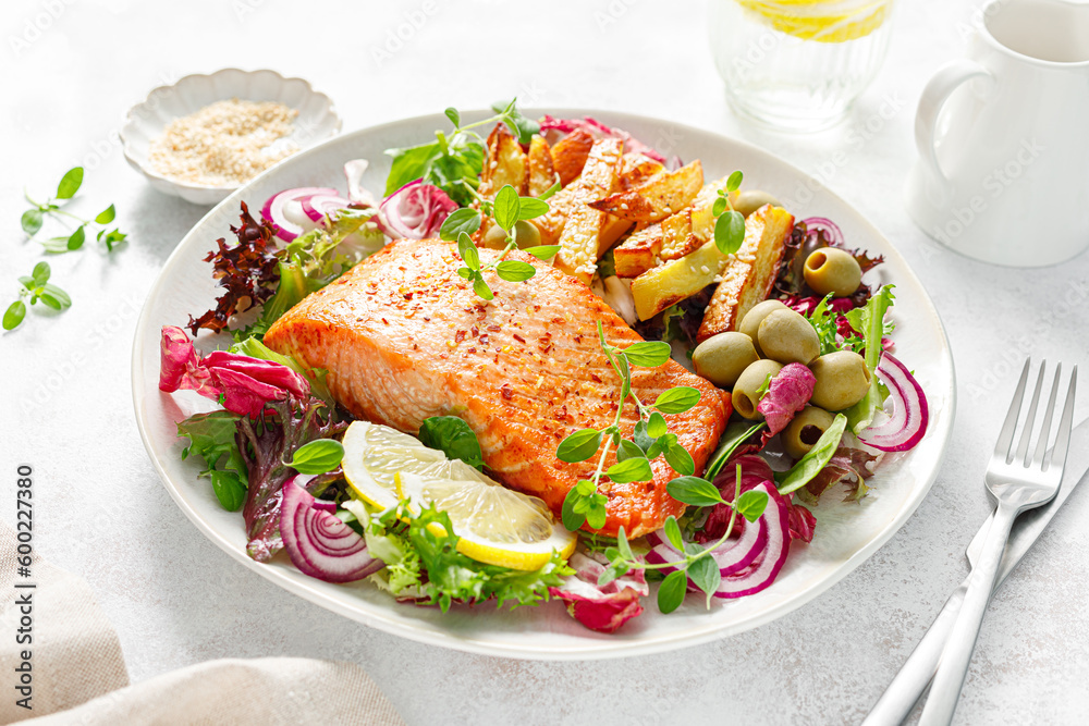 Salmon fillet grilled, fried potato and fresh vegetable green salad Salmon fillet grilled, fried potato and fresh vegetable green salad