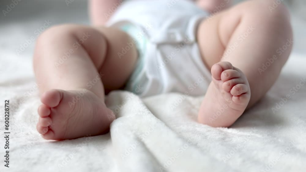 close up baby body parti cute hand fingers legs sole sitting on bed blanket. mother kissing infant toddler feet massage with hands. child moving uncontrollably.motherhood concept advertising 4k close up baby body parti cute hand fingers legs sole sitting on bed blanket. mother kissing infant toddler feet massage with hands. child moving uncontrollably.motherhood concept advertising 4k