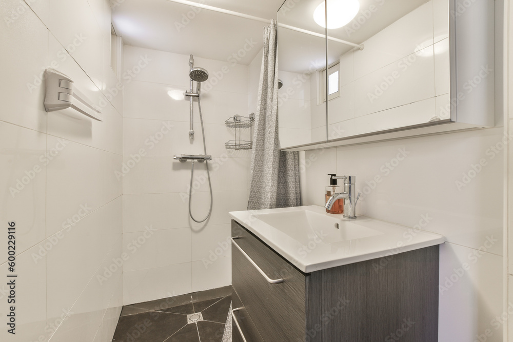 a bathroom with white walls and wood flooring in the shower area, while it appears to be used as a sink a bathroom with white walls and wood flooring in the shower area, while it appears to be used as a sink