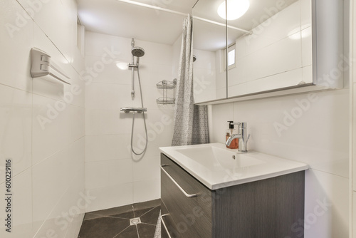 a bathroom with white walls and wood flooring in the shower area, while it appears to be used as a sink