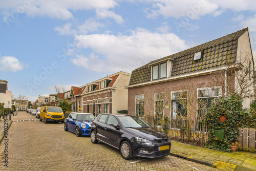 a car parked on the side of a road in front of a house with a blue sky and white clouds © Casa imágenes