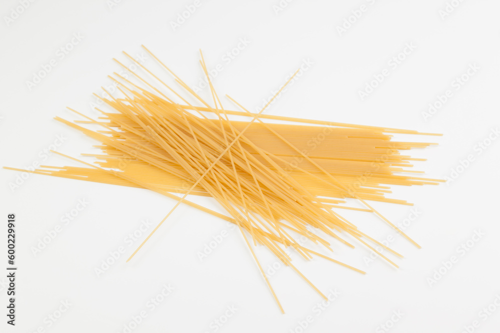 Spaghetti spread out on a white surface.