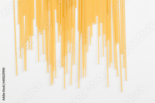 Spaghetti spread out on a white surface.