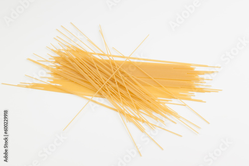 Spaghetti spread out on a white surface.