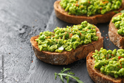 Mashed peas sourdough bread toast with sea salt flakes and chilli served on black slate