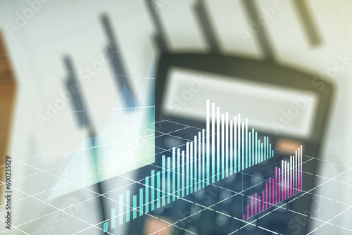 Abstract virtual financial graph hologram on blurry calculator and papers background, financial and trading concept. Multiexposure © Pixels Hunter