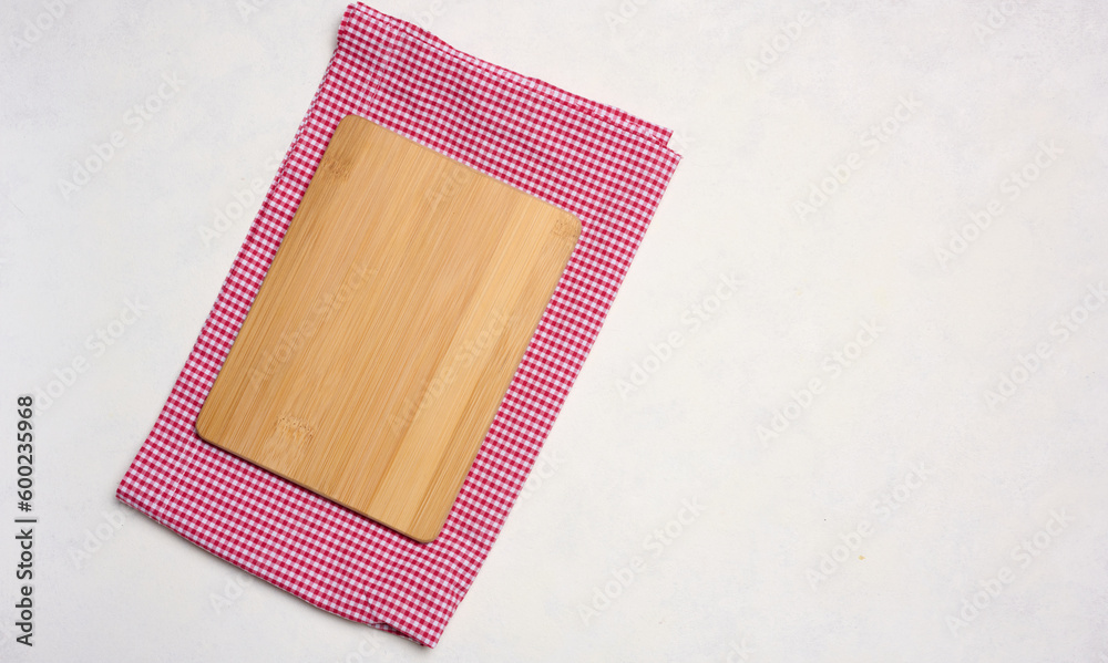 Empty wooden cutting board and red towel on white background. Copy space Empty wooden cutting board and red towel on white background. Copy space