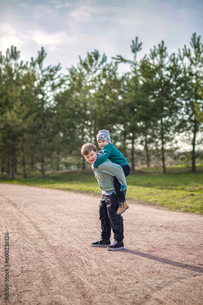 Two funny boys-brother and friend, walking together in the spring park, running, jumping and enjoying. Two funny boys-brother and friend, walking together in the spring park, running, jumping and enjoying.
