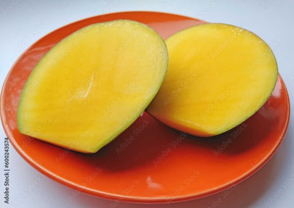 pieces of ripe sliced mango fruit on a plate. Closeup of fresh juicy tropical mango ready to eat healthy sweet dessert, vegan food.