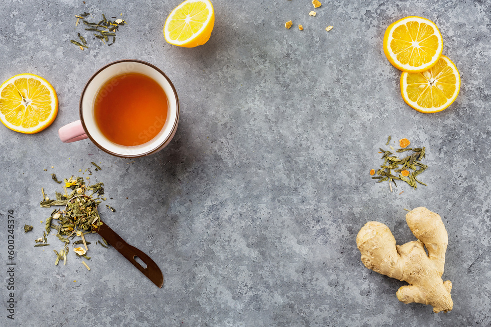Cup of healthy ginger tea with lemon on gray table. Space for your text. Top view