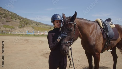 Teenage horse rider petting horse and bonding during equine therapy
