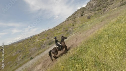 Fpv drone view of horse rider horseback riding in nature