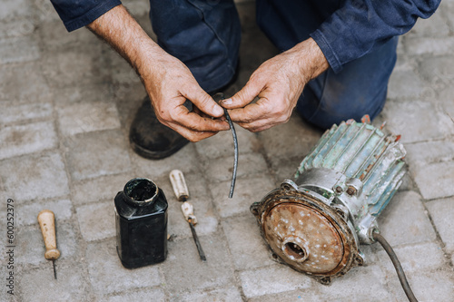 A man is a professional, an electrician, an electromechanic repairs an electric motor. Photography, portrait. photo