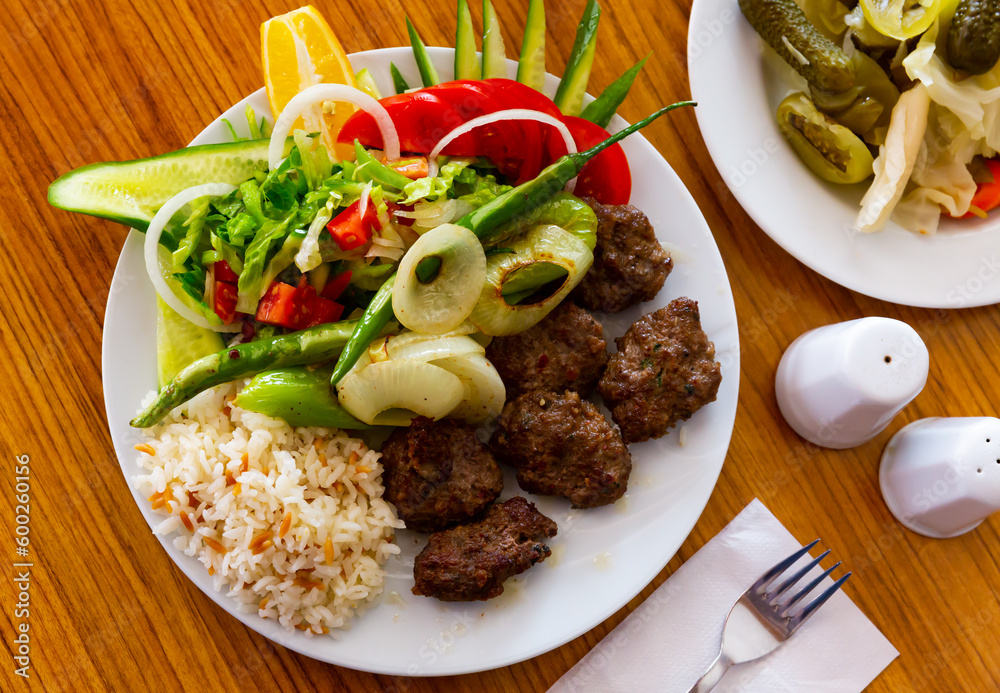 Plate of turkish kofte meatballs with rice and salad