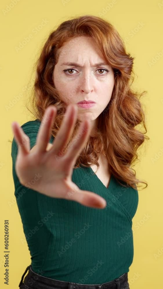 Redheaded woman gesturing prohibition with hand Redheaded woman gesturing prohibition with hand