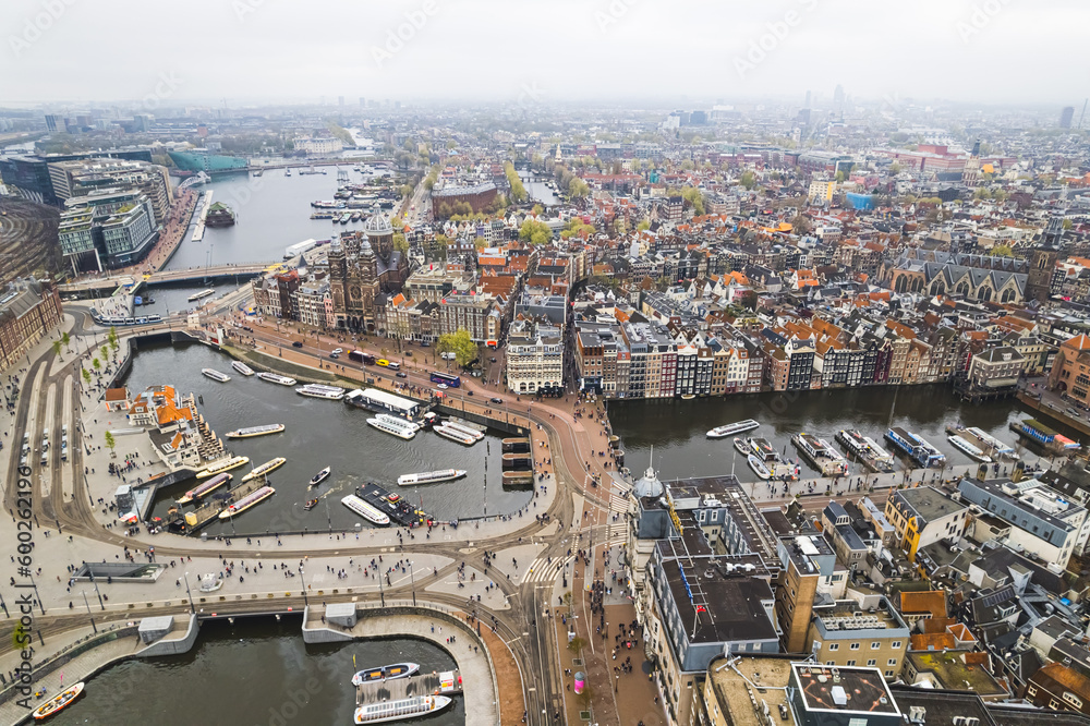 Obraz premium scenic drone shot of Amsterdam City center, canals with colorful houses, harbor and houses. High quality photo