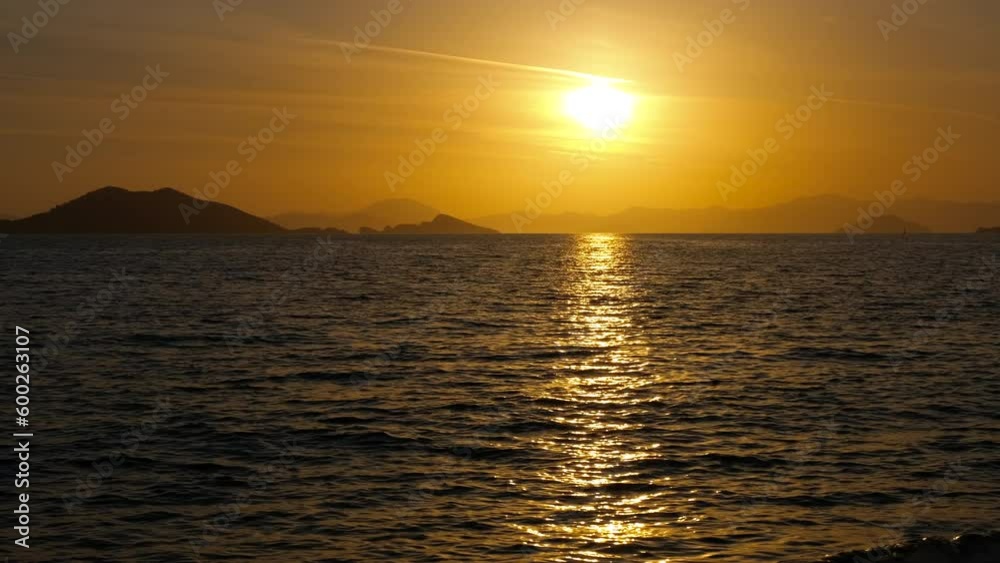 Sunset in bight silhouette. A nice orange and yellow sun silhouette by the calm sea waves in summer. Sunset in bight silhouette. A nice orange and yellow sun silhouette by the calm sea waves in summer.