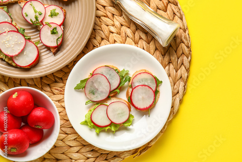 Plates with delicious radish bruschettas on yellow background