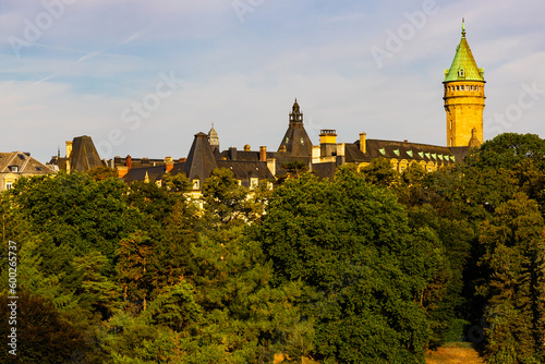 Picturesque view of clock tower and building of Luxembourg Bank Spuerkeess behind trees