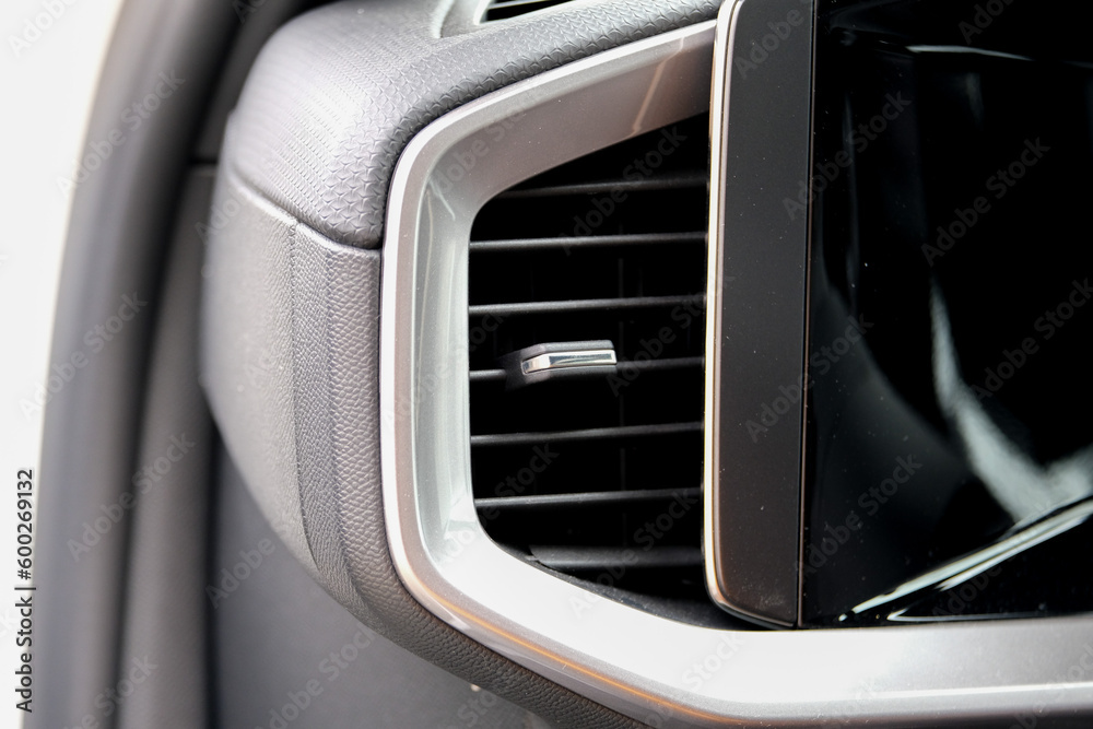 Close up modern heat vent inside car near car display screen. Close up modern heat vent inside car near car display screen.
