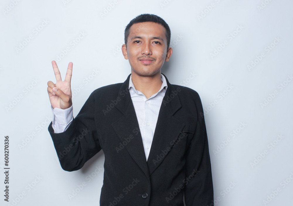 Smiling young Asian man wearing shirt with hand peace sign isolated on white background. Smiling young Asian man wearing shirt with hand peace sign isolated on white background.