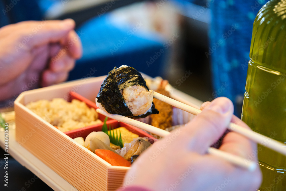 Unrecognizable person eating Japanese Eki Bento on a Shinkansen Train in Japan.